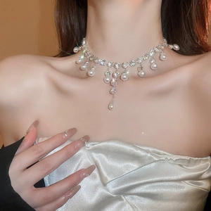 Detail of silver drop pearl necklace with sparkling zircon tassels on a model