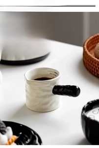 Macro detail of ceramic milk pitcher with 90ml scale and elegant ripple texture