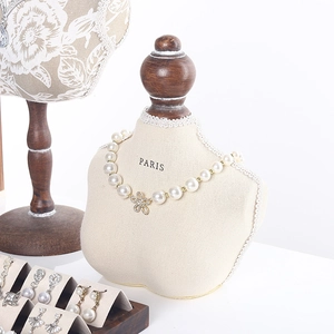 Walnut jewelry organizer stand with pearl necklace and various earrings on a mannequin