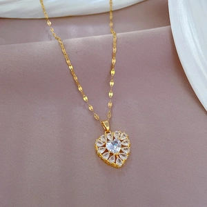 Luxurious gold heart pendant necklace with shimmering zircon crystals on silk fabric