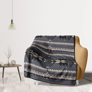 Close-up of flannel throw blanket with ethnic geometric patterns on a yellow sofa