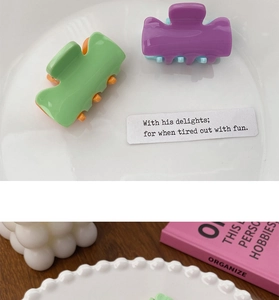 Mini candy-colored hair claws on an aesthetic table setting with a ceramic plate