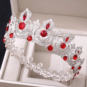 Macro detail of silver bridal crown featuring red gemstones and sparkling rhinestones