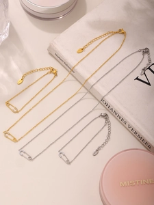 Detail van goud- en zilverkleurige roestvrijstalen paperclip kettingen en armbanden met zirkoon