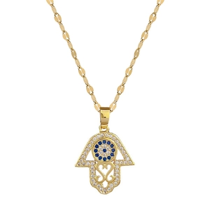 Titanium steel Hamsa eye necklace with gold finish and blue inlaid gems on white backdrop