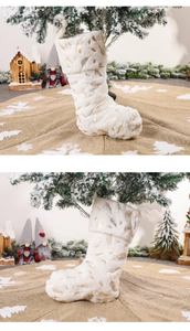 Detail of white faux fur Christmas stocking featuring golden feather patterns on a tree