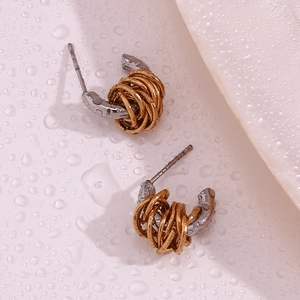 Close-up of two-tone twisted knot C-shape earrings on a refreshing water droplet surface
