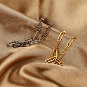 Polished silver and gold chain earrings with paperclip link design on silk fabric