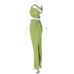 Detail of green two-piece set featuring a halter crop top and side-knotted slit maxi skirt