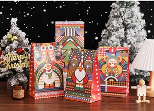Festive Christmas paper gift bags with Santa and snowman illustrations in a cozy holiday setup
