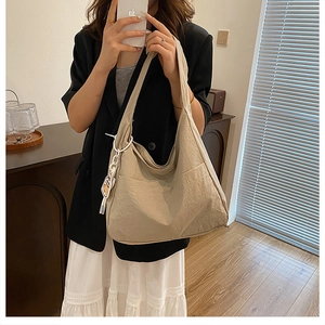Detail of canvas tote bag with side pocket and wide shoulder strap in daily life use