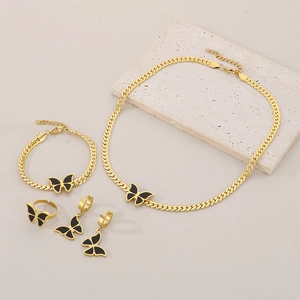 Detail of 18k gold plated jewelry set with black acrylic butterflies and Cuban chain