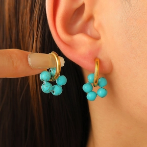 Golden hoop earrings with turquoise beaded rings shown on model in a stylish close-up