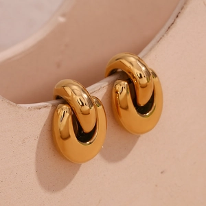 Detail of 18K gold plated stainless steel geometric hoop earrings on ceramic surface