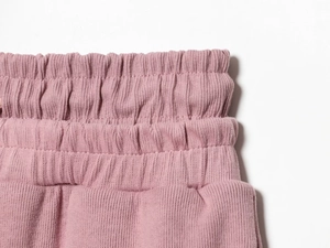 Détail d'un vêtement de détente en tricot rose avec taille élastique côtelée