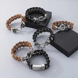 Detail view of woven leather bracelets with skull and dragon charms on geometric stands