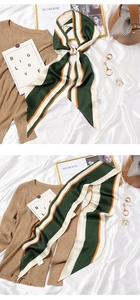 Detail of green, white, and orange striped silk scarf styled with a brown leather bag