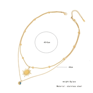 Detail view of gold stainless steel double layer necklace with sun and evil eye pendants