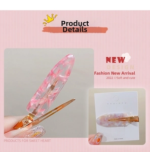 Detail of pink marble pattern acetate hair clip with gold metal base on display card