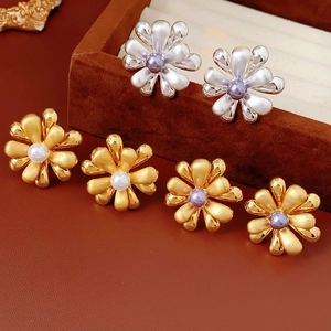 Detailed macro view of 18k gold and silver plated flower earrings with pearls