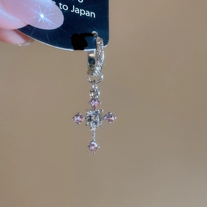 Detail of silver cross drop earrings with pink and white crystal zircon inlay
