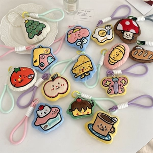 Detailed close-up of cute plush cartoon keychains with braided ropes on a white desk