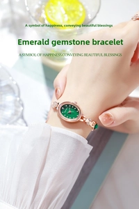Detailed view of women's rose gold luxury watch with emerald green dial on wrist