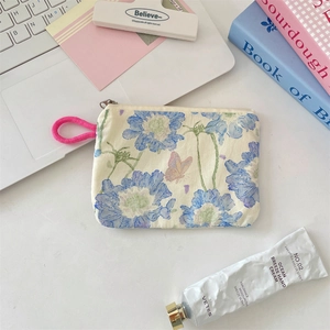 Macro detail of floral canvas pouch with pink lanyard on a minimalist desk setting
