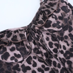 Detail of leopard print dress featuring ruffled edges and front lace-up tie closure