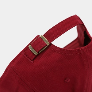 Détail de la boucle en métal réglable et des coutures sur la casquette bordeaux enfant