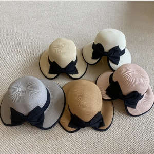 Cinco sombreros de paja con lazos de cinta negra y bordes finos decorativos