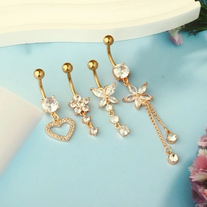 Detail of four golden belly rings with heart, butterfly, and tassel zircon charms