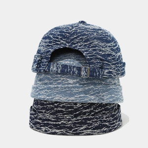 Three stacked vintage washed denim docker caps in blue shades with adjustable metal buckles