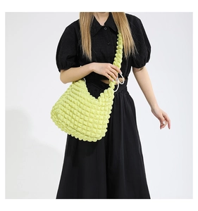 Detail of lime green popcorn texture fabric and pleated shoulder strap on casual bucket bag