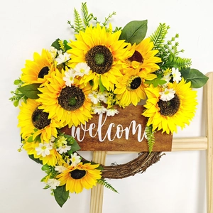 Détail d'une couronne de tournesols avec panneau Welcome rustique pour décoration de porte