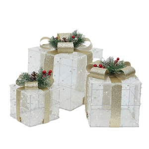 Three-piece white translucent Christmas gift boxes with gold ribbons and pine needles