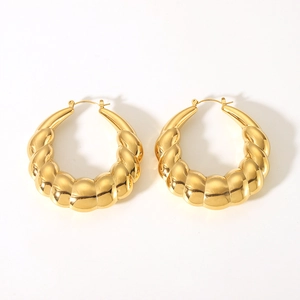 Detail of chunky twisted hollow hoop earrings in 18K gold plated polished stainless steel