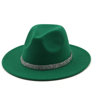 Détail d'un chapeau en feutre vert foncé orné d'un ruban décoratif à paillettes argentées