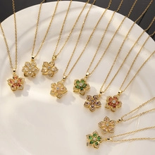 Close-up of assorted colorful flower zircon pendants on golden chains in a white tray