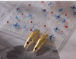 Macro detail of TL-2 nail art stickers with 3D Chinese floral patterns and gold accents