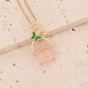 Elegant gold butterfly and pink glass rose pendant necklace on minimalist stone background