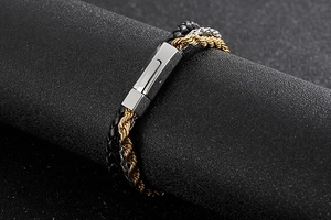 Detail of multi-layer men's bracelet with woven leather and metallic chain textures