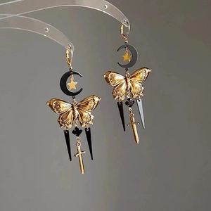Detailed view of crescent moon and star earrings with gothic sword and cone pendants