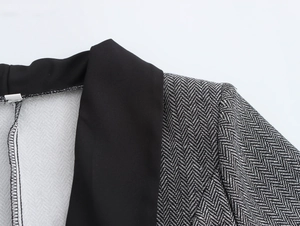 Close-up of contrast black lapel and herringbone wool fabric on elegant suit jacket