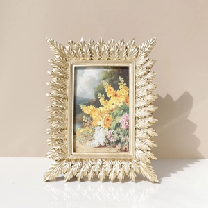Golden resin leaf photo frame in retro American style with intricate foliage design