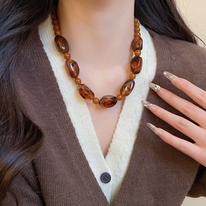 Close-up of amber irregular acrylic beaded necklace on neck for vintage aesthetic look