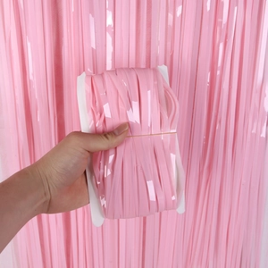 Pink tinsel foil fringe curtain for birthday party backdrop decoration, close-up shot