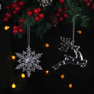 Close-up of clear acrylic snowflake and reindeer hanging ornaments with silver strings