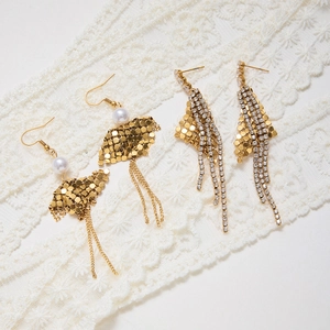 Detail of gold geometric fringe earrings with white zircons and pearl accents