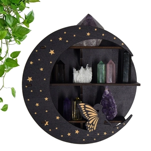 Detail of black moon-shaped wooden shelf with fairy silhouette and crystals